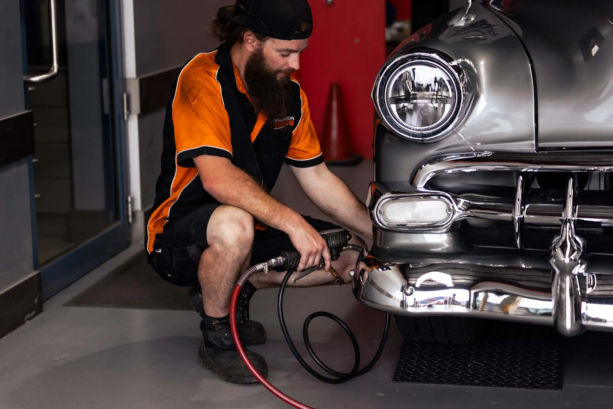 A Williamson Tyreco technician inflating the tyre of a classic chrome car