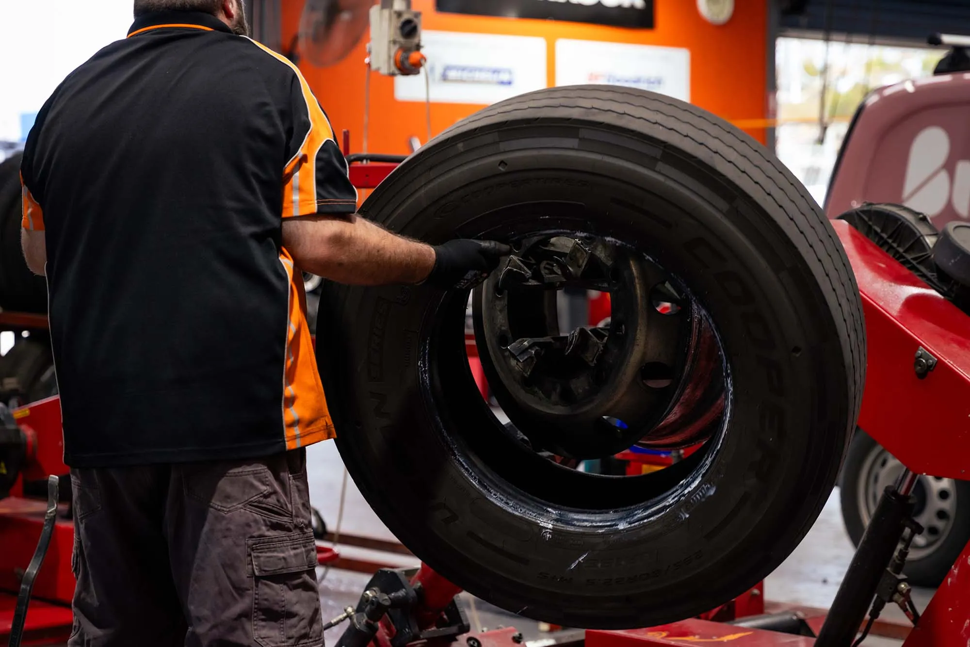A Williamson Tyreco technician fitting a large truck tyre onto a wheel